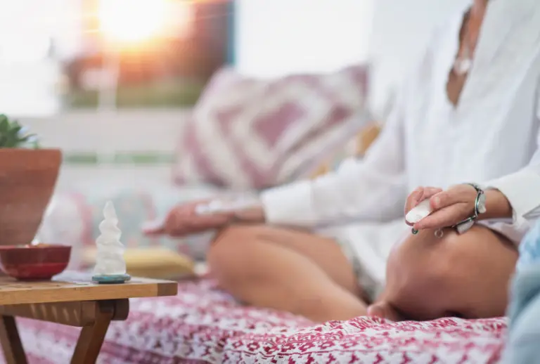 Woman meditating with healing crystals in a peaceful setting