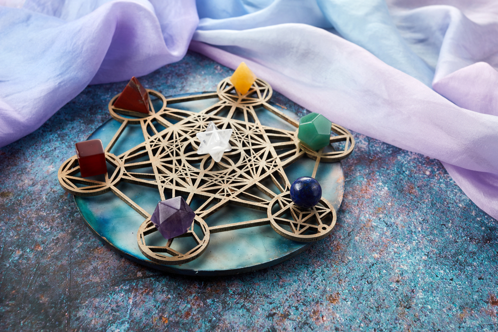 Crystal grid with geometric gemstones placed on Metatron’s Cube sacred geometry base